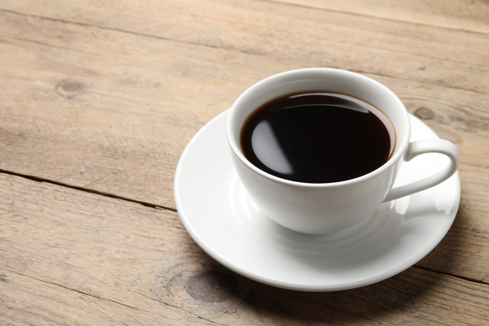 Cup of aromatic coffee on wooden table.