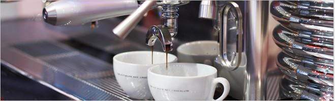 weaverscoffee.sbs Two white coffee cups at an espresso machine filled with Espresso Coffee.